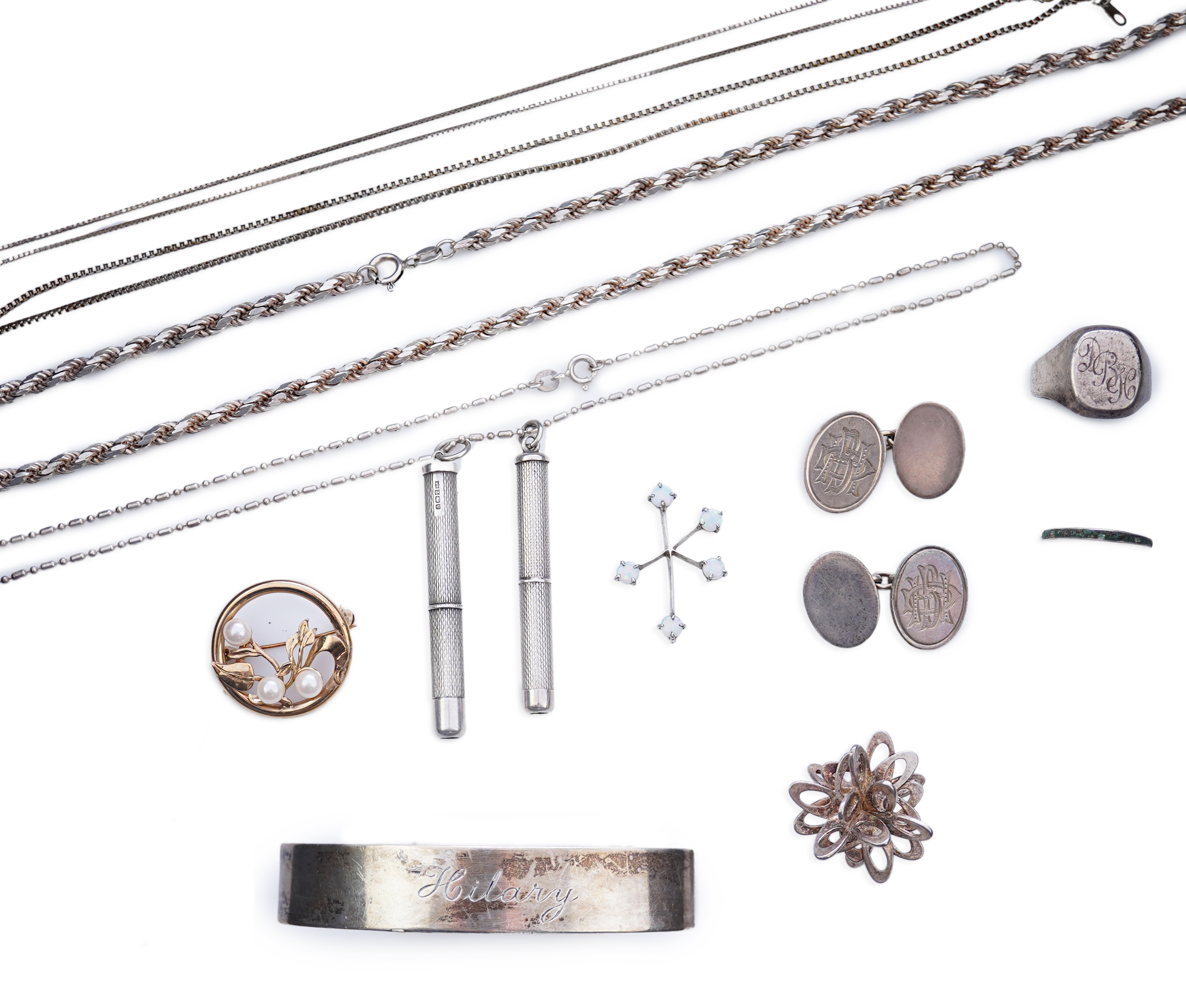 A collection of silver jewels, comprising: a bangle; a chain necklace suspending two winding toothpicks, one with toothpick deficient; a rope twist chain; a pair of cufflinks with the initials DBH; a pendant of abstract